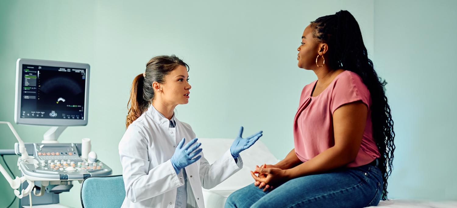 A doctor talks to a woman during medical examination at a clinic.