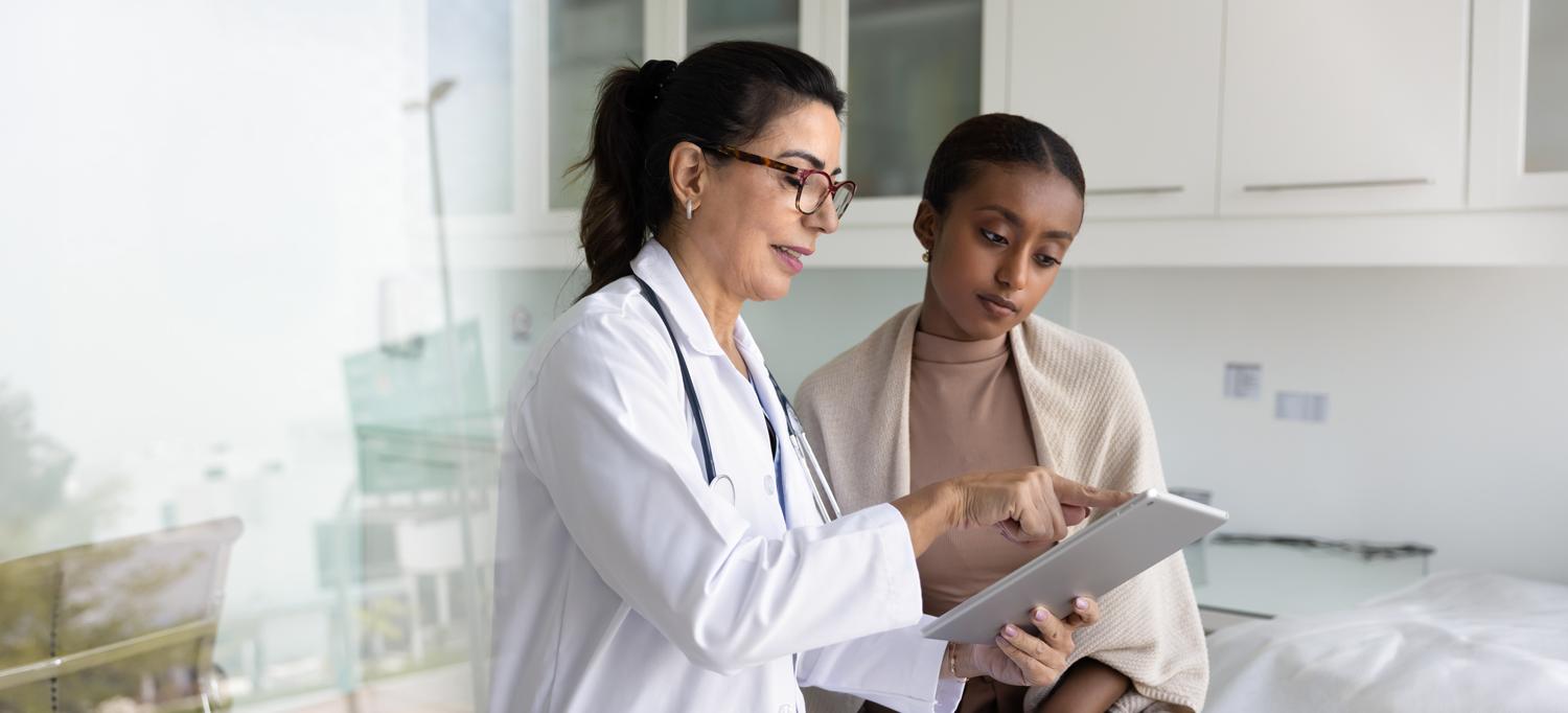 A doctor shows a tablet with results to a patient.