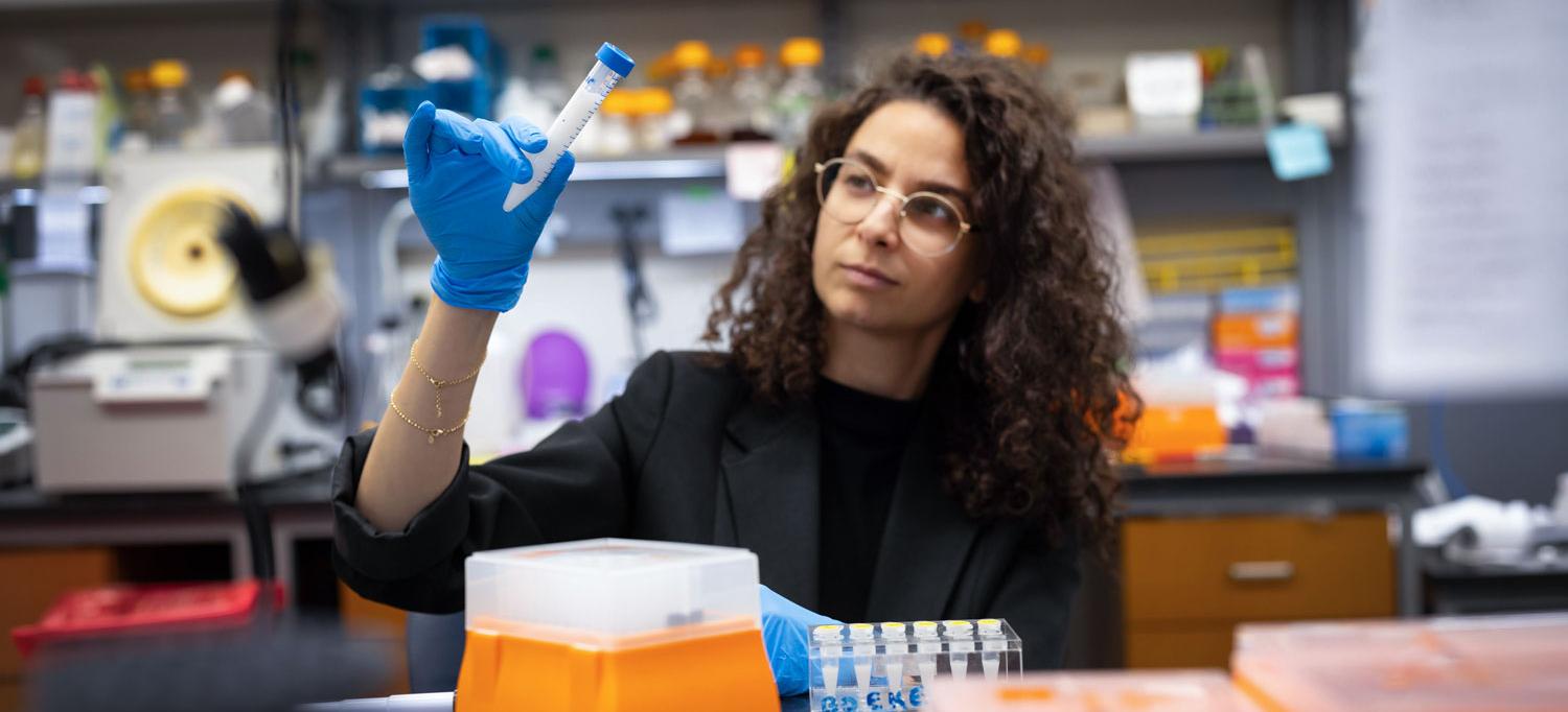 Liat Shenhav, PhD, examines test tubes containing milk.