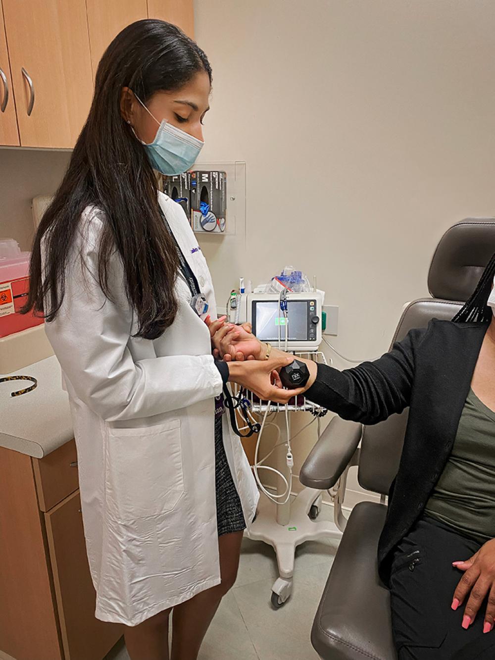 Dr. Juhi Purswani Using Portable Spectrophotometer to Examine the Skin of a Woman of Color