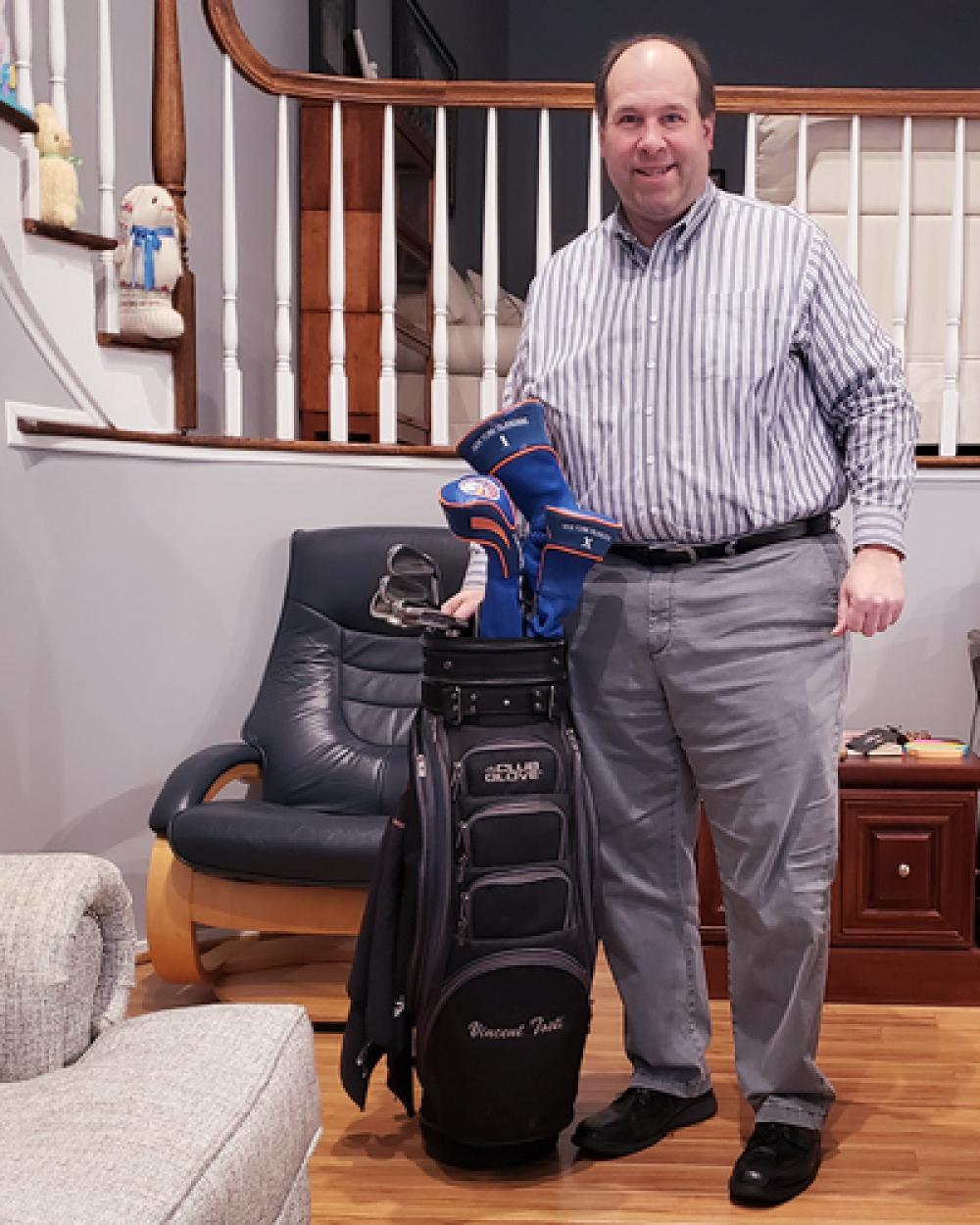 Vincent Tosti at Home Standing Next to His Set of Golf Clubs