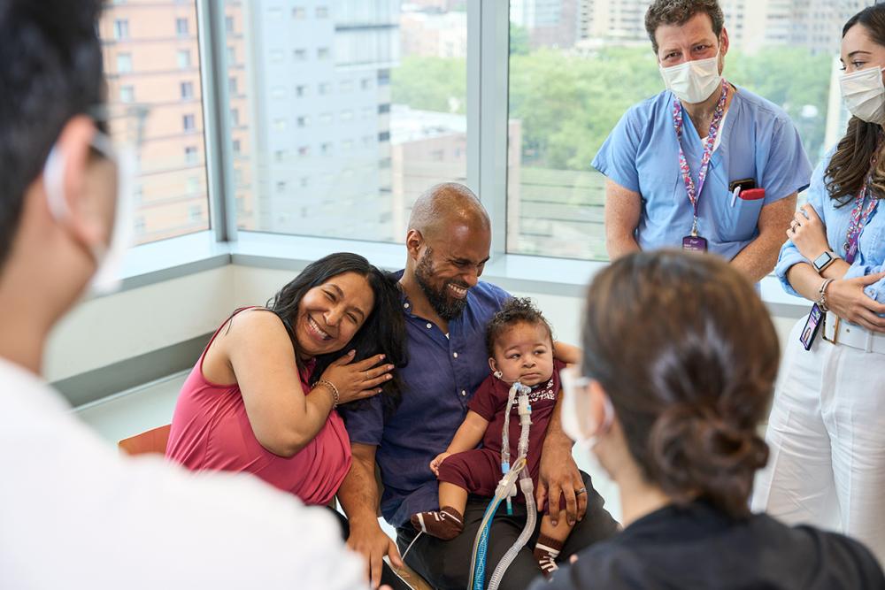 Aydin Sits on His Father Jamaal’s Lap as Yadi Embraces Jamaal and Doctors and Nurses Look On