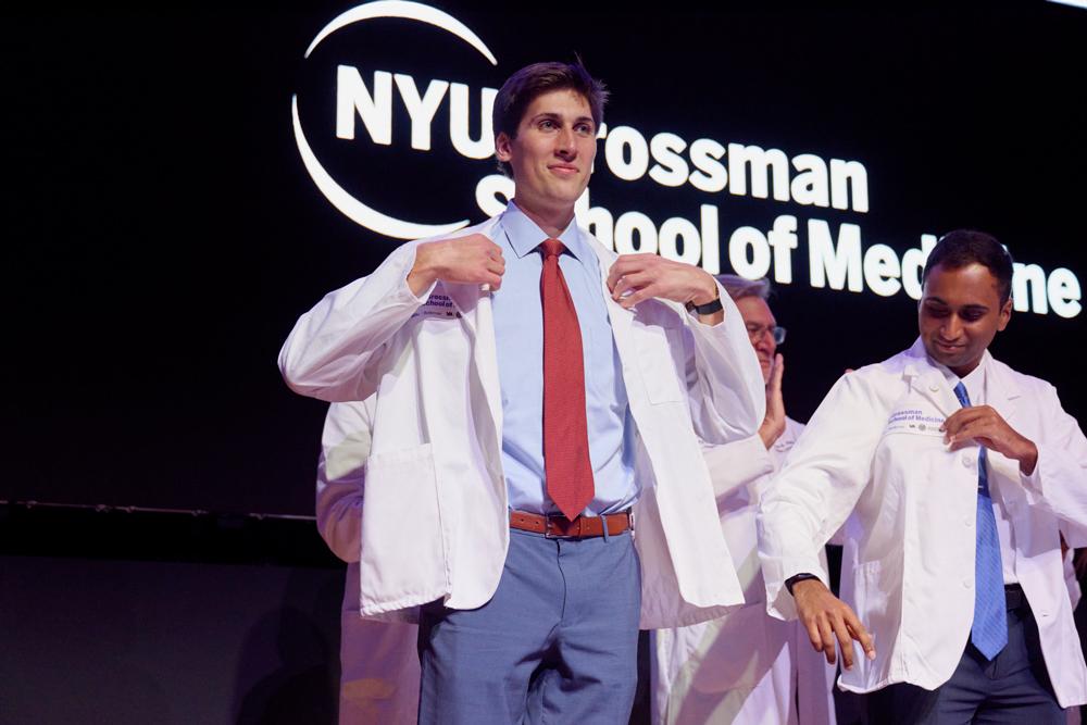 Standing on stage, O'Shaughnessy receives his white coat during the ceremony.