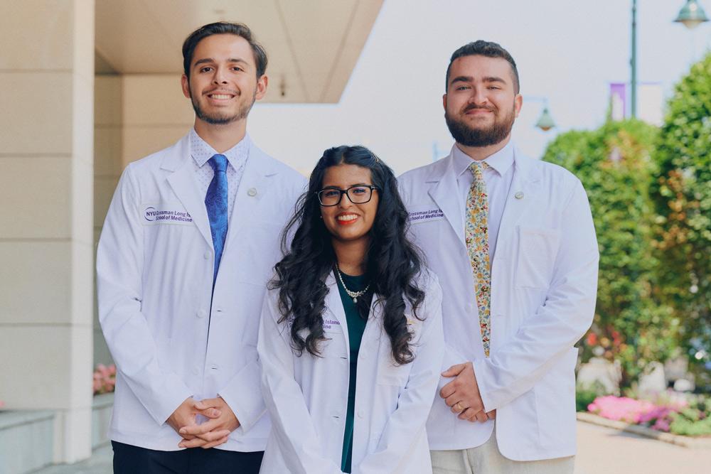 Three incoming students in their white coats.