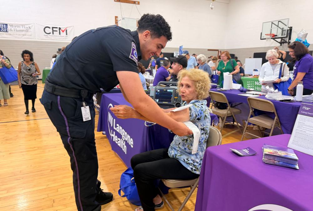 An EMS worker conducts a blood pressure test on an older woman. 