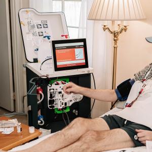 Conor Malangone Seated at Home Using Dialysis Machine