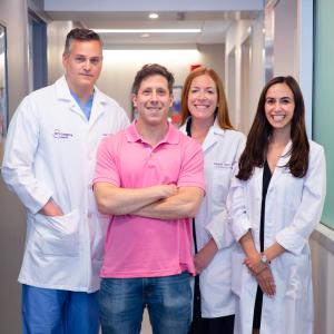 Phil Passen stands with Dr. Peterson and other staff in a hospital hallway. 