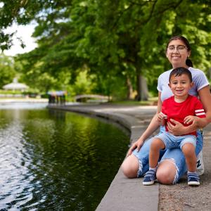 Alma and Malik sit smiling in the park.