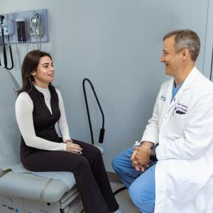 Gonzalez speaks to Dr. Adam Griesemer in an examination room.