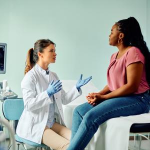 A doctor talks to a woman during medical examination at a clinic.