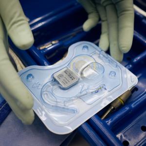 Gloved person handling a cochlear implant.