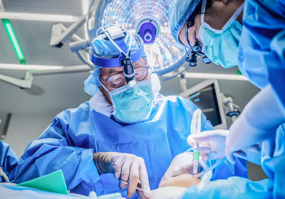 Dr. Robert Montgomery stands over an operating table wearing full personal protective equipment (PPE).